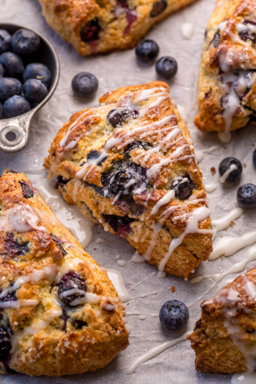 Blueberry scone recipe with vanilla glaze on baking sheet